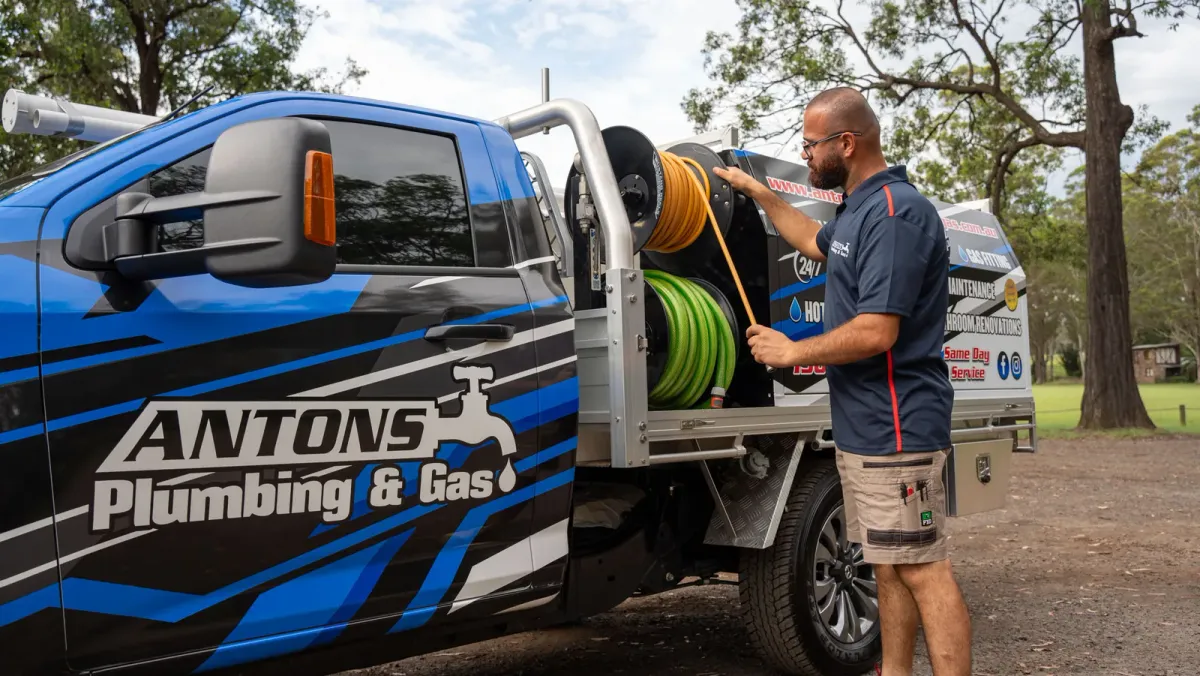 Experienced Antons plumber preparing professional drain-cleaning equipment on a service vehicle